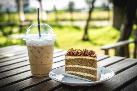 slice coffee cake with almond nut and butter cream and ice coffeeの写真素材