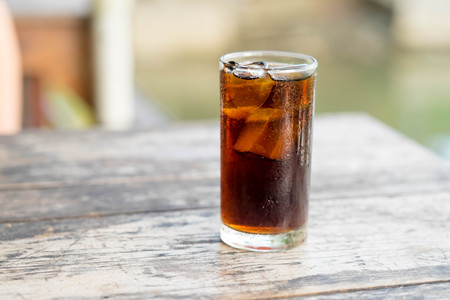 A glass of cola with ice cubesの写真素材