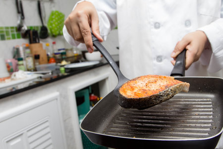 chef making fresh salmon steak on wooden boardの写真素材
