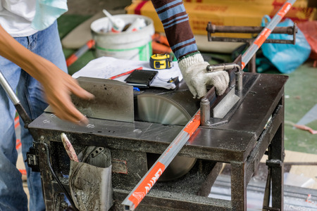man hand using machine to cut aluminum in work shopの写真素材