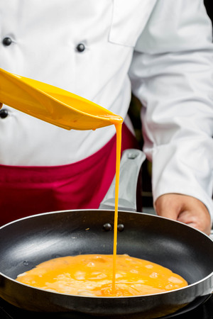 chef making cook omelet in panの写真素材
