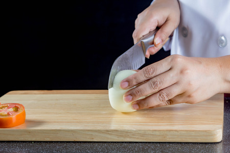 chef chopped onions on wooden boardの写真素材