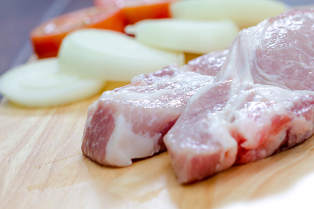 fresh pork and onion on a wooden boardの写真素材