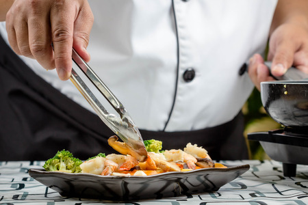 chef making Stir-Fried Broccoli carrot, baby corn with prawnsの写真素材