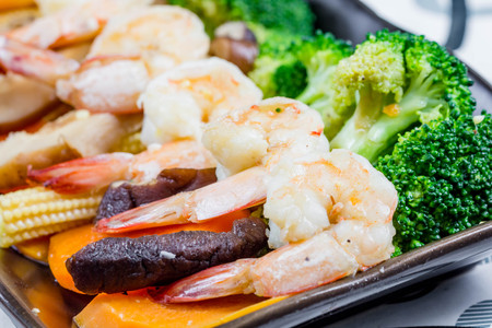 chef making Stir-Fried Broccoli carrot, baby corn with prawnsの写真素材