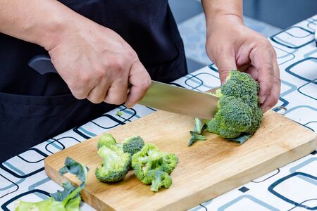 chef sliced broccoli on wooden boardの写真素材