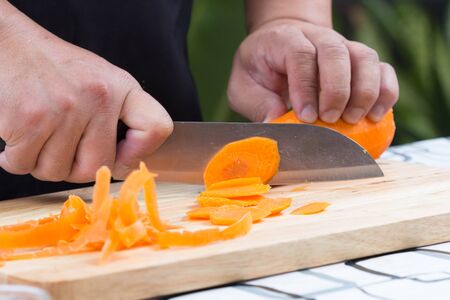 chef sliced carrot on wooden boardの写真素材