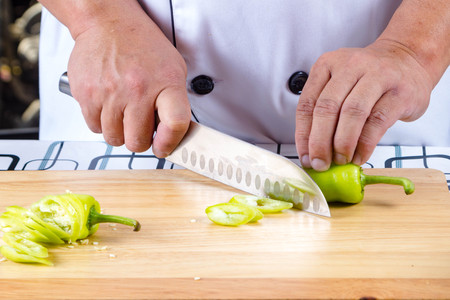 Chef cutting bell pepper  on cutting boardの写真素材
