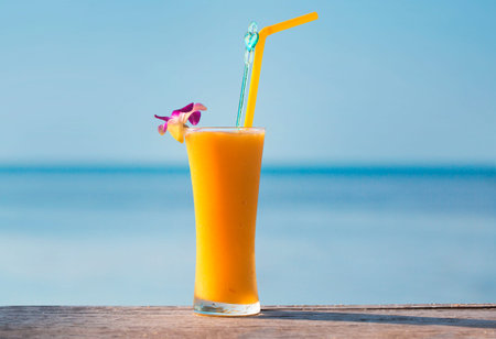 glass of fresh mango on the table on sea background