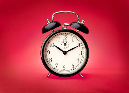 Alarm clock on a red background. Studio shotの写真素材
