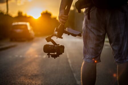 Man holding a camera with gimbal stabilizer outdoor.の写真素材