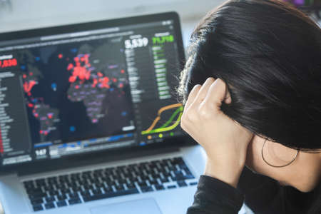 Coronavirus concept:  A woman reading news/updates about coronavirus and getting anxiety/depression.の写真素材