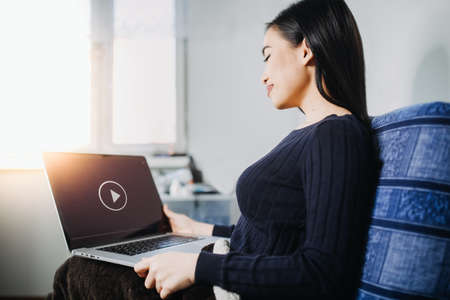 A woman watching video streaming at home. Coronavirus outbreak quarantine. Stay at home order. Activities during Coronavirus outbreak. Self-quarantine.の写真素材