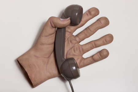 Top view of huge hand holding a phone receiverの写真素材
