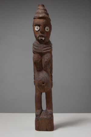 Antique african wooden statue standing against grey backgroundの写真素材