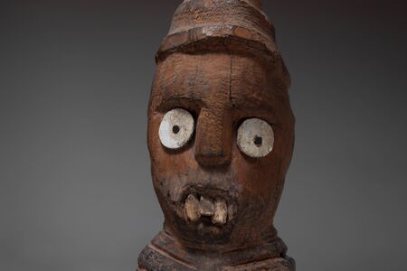 Antique african wooden statue against dark backgroundの写真素材