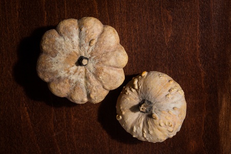 Top view of two small dry pumpkins on a wooden surfaceの写真素材