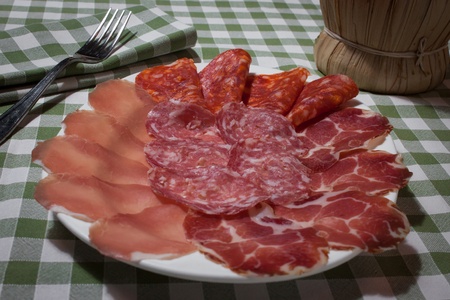 Plate of italian cold meat on a green and withe tableclothの写真素材