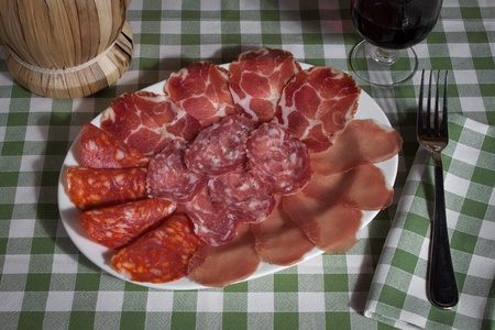 Plate of italian cold meat on a green and withe tableclothの写真素材