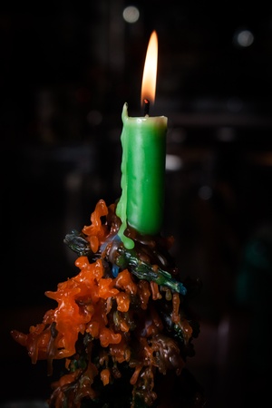 Green wax candle on dark backgroundの写真素材