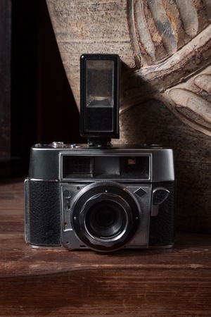 Vintage camera with flash on wooden surfaceの写真素材
