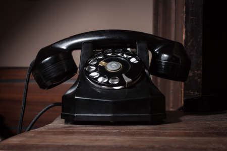Black vintage telephone on a wooden surfaceの写真素材