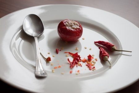 White dish with red peppers on wooden surfaceの写真素材