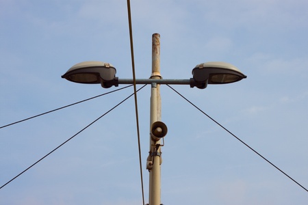 Detail of a lamppost with a small loudspeaker against the skyの写真素材