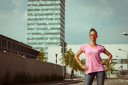 Portrait of a beautiful girl with pink glasses posing in the streetの写真素材