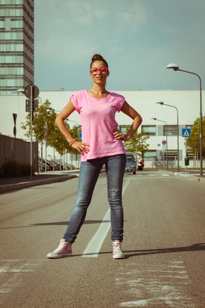 Portrait of a beautiful girl with pink glasses posing in the streetの写真素材