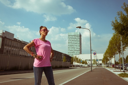 Portrait of a beautiful girl with pink glasses posing in the streetの写真素材