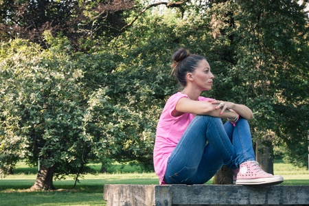 Portrait of a beautiful sitting in a city parkの写真素材