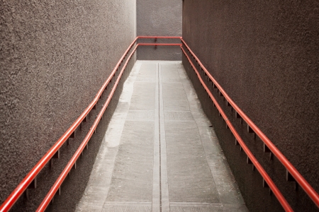 Empty urban underpass with orange handrailsの写真素材