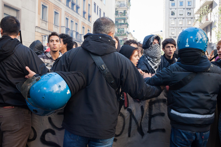 MILAN, ITALY - OCTOBER 11  Riot police confronts secondary school students marching in the city streets to protest against money cuts in the public school on October 11, 2013 in Milan のeditorial素材