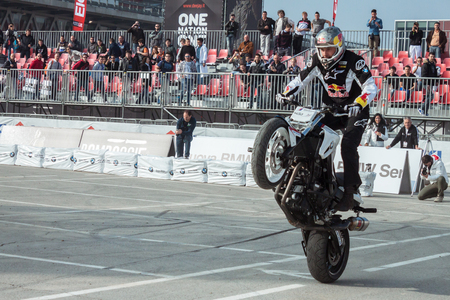 MILAN, ITALY - NOVEMBER 7  Acrobatic biker shows his ability on a wheel at EICMA, international motorcycle exhibition on NOVEMBER 7, 2013 in Milan のeditorial素材