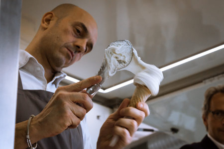 MILAN, ITALY - NOVEMBER 16: Man prepares an ice cream cone at Golosaria, important event dedicated to culture and tradition of quality food and wine on NOVEMBER 16, 2013 in Milan.のeditorial素材