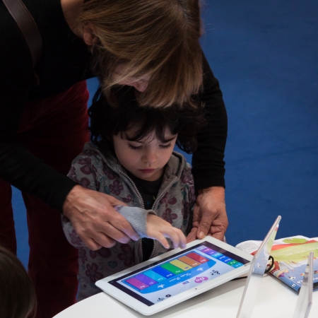 MILAN, ITALY - NOVEMBER 22  Child plays with tablet at G  come giocare, trade fair dedicated to games, toys and children on NOVEMBER 22, 2013 in Milan のeditorial素材