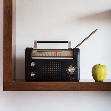 Vintage radio with yellow apple on a shelfの写真素材