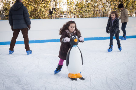 MILAN, ITALY - DECEMBER 27: People have fun skating on a public ice rink built up in the city streets by Municipality during the Christmas period on DECEMBER 27, 2013 in Milan.のeditorial素材