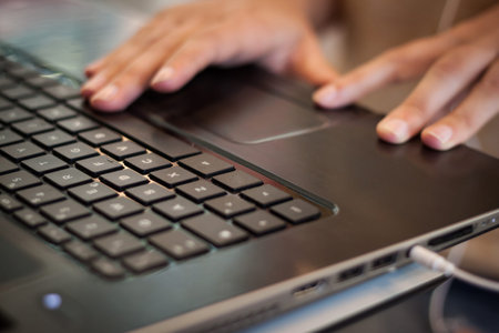 Detail of female hands working on computer keyboard