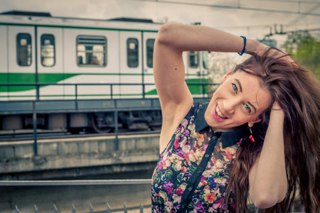 Pretty girl with long hair posing on railroad bridge