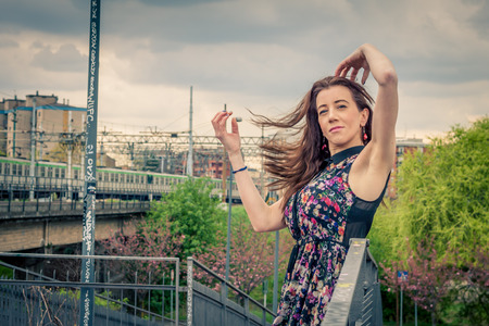 Pretty girl with long hair posing on railroad bridgeの写真素材