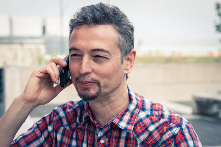 Man in short sleeve shirt talking on phone in the street