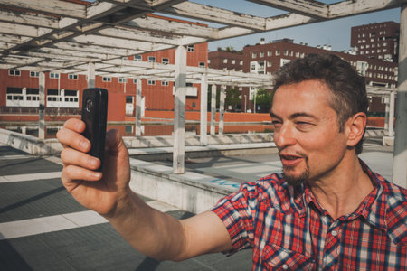 Man in short sleeve shirt taking a selfie in the street
