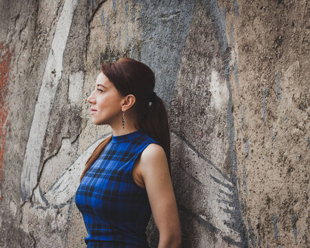 Pretty girl posing against a concrete wall in the streetの写真素材