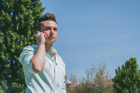 Short hair girl with hoodie talking on phone の写真素材