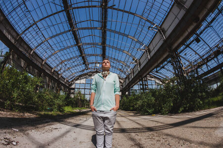 Fisheye portrait of short hair girl with hoodie posing in an abandoned factoryの写真素材