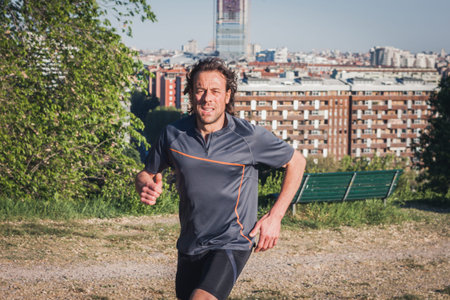 Mature long haired athlete running in a city park