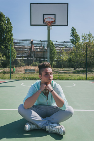 Short hair girl with hoodie in a basketball playgroundの写真素材