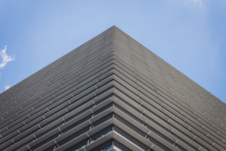 Architectural detail of a modern building against blue sky with clouds
